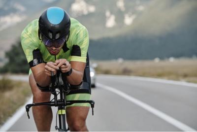 Cyclist riding in aerodynamic position on open road